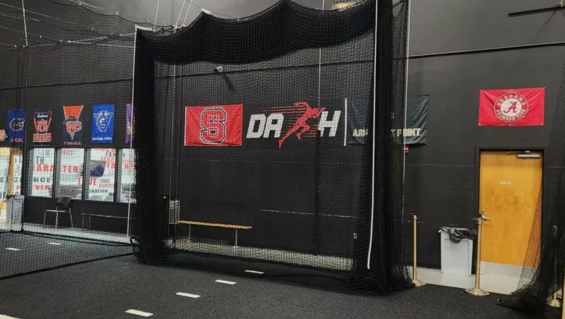 Indoor batting cage retracted along ceiling-mounted cables to free floor space