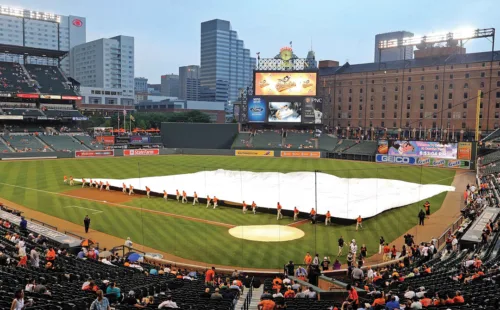 grounds crew pulling out rain tarp at camden yards