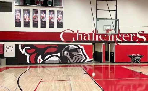 Custom printed gym wall padding mounted along a gymnasium wall to protect athletes