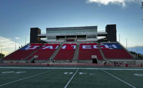 Custom stadium seat covers with Utah Tech branding installed on arena seating sections