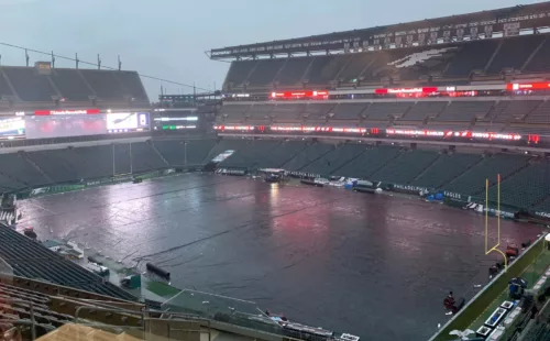 Black football field tarp providing complete rain protection at Lincoln Financial Field during wet weather conditions