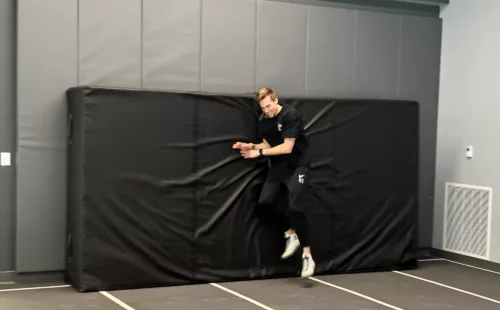 Black indoor track pad with high-density foam core for pole vault and high jump training