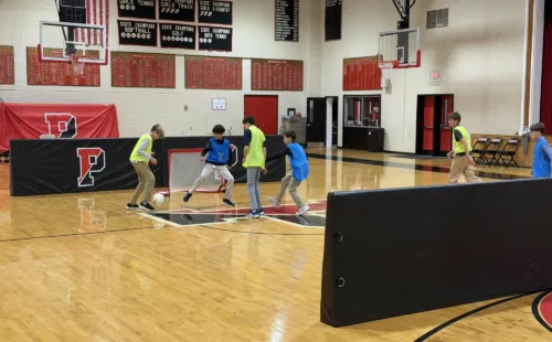 Protective barrier pads installed on indoor gym walls providing cushioned safety padding for basketball courts, volleyball facilities, and multipurpose athletic spaces