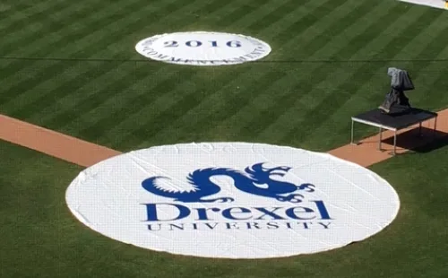 Custom printed rain spot covers with Drexel University logo on pitching mound and on-deck circle of a college baseball field